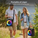 Two people walk outdoors with portable speakers that glow in rainbow colors. They’re smiling and enjoying music on a sunny trail.