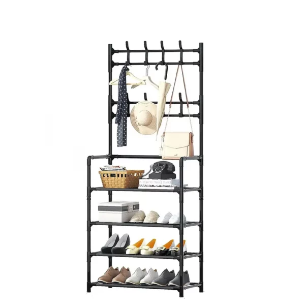 A freestanding black multi-tier clothing rack with hangers, hats, bags, and scarves hanging on top shelves and several pairs of shoes on the lower shelves.
