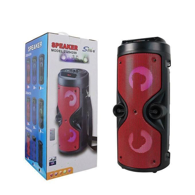 1 (37) Red portable Bluetooth speaker with two round drivers, shown beside its packaging box.