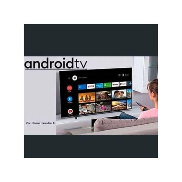Living room scene with a person sitting on a sofa and using a remote to watch Android TV on a large flat-screen TV showing app thumbnails