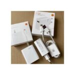 White 33W USB-C power adapter kit with cable and packaging on a cardboard surface, unboxed and arranged neatly.