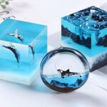 Blue ice-like cubes and a clear glass ornament displaying manta rays, creating an underwater icy decor piece.