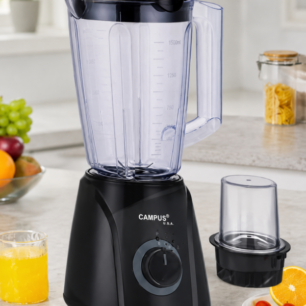 Black Campus USA blender with large transparent pitcher and lid on a kitchen counter; juice and fruit nearby, plus a separate blending cup on the side.
